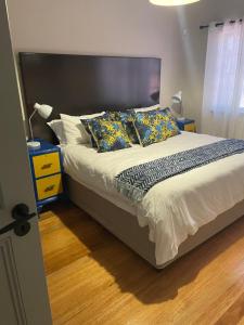Mount Road Suites في بورت اليزابيث: غرفة نوم مع سرير كبير مع اللوح الأمامي الأسود