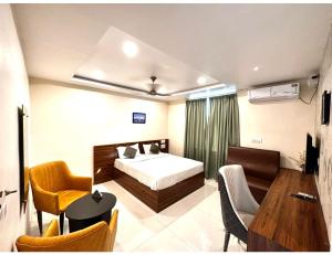 um quarto com uma cama, uma mesa e cadeiras em Sagar Regency And Lodge, Bidar em Bīdar
