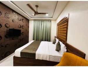um quarto com uma cama e uma televisão na parede em Sagar Regency And Lodge, Bidar em Bīdar