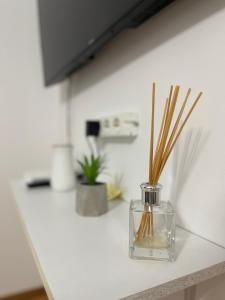 a glass vase with sticks in it on a counter at BUTTERFLY FAMILY APARTMENT SIBIU in Sibiu