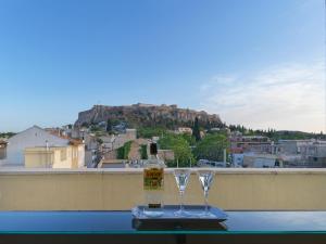a bottle of wine and two glasses sitting on a table at Luxurious Top Floor Acropolis View Loft in Plaka - Newly Refurbished in Athens