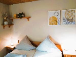 Zimmer mit einem Bett mit zwei Kissen darauf in der Unterkunft Apartment Andrea in Inzell
