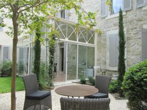 a patio with a table and chairs in front of a building at N15 - Les Confidences - Chambres d'hôtes in Avignon