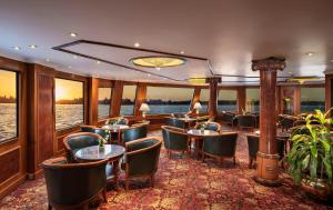 un restaurante en un crucero con mesas y sillas en Sonesta St George Nile Cruise - Aswan to Luxor 3 Nights from Friday to Monday en Asuán