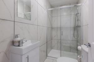 a white bathroom with a shower and a sink at York Villas Free Parking Included in Liverpool