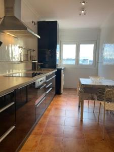 een grote keuken met een tafel en een aanrecht bij Apartamento corredoira in Monforte de Lemos