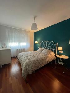 - une chambre avec un lit et un mur vert dans l'établissement Apartamento corredoira, à Monforte de Lemos
