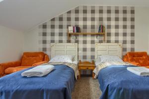 a bedroom with two beds and a couch at Agroturystyka nad jeziorem Sopień in Brzozie