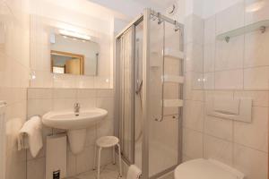 a white bathroom with a sink and a shower at Kurpark-Residenz 218A in Döse