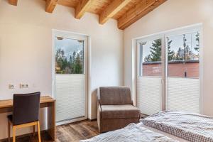 a bedroom with a bed and a desk and a chair at Ferienwohnung Wetterstein in Ehrwald