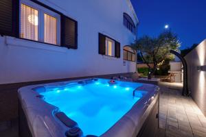 una bañera de hidromasaje frente a una casa por la noche en Villa Demonta, en Trogir