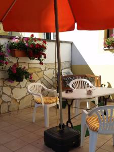einen Tisch und Stühle mit Sonnenschirm auf einer Terrasse in der Unterkunft Pension Eissler in Bruchsal