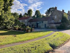 una casa vieja con un patio de hierba delante de ella en The Loft, 1 Bedroom flat in rural village, en Lockton