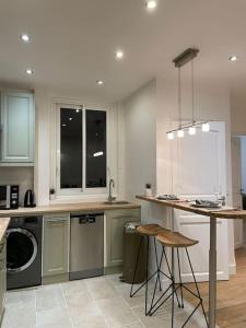 a kitchen with a washer and a sink and a table at Paris15 eme Chic appartement atypique et calme in Paris