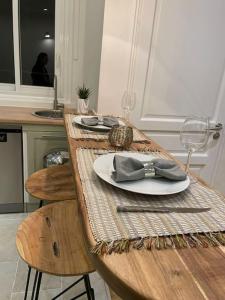 una mesa de madera con un plato con una pajarita. en Paris15 eme Chic appartement atypique et calme, en París