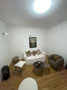 sala de estar con sofá blanco y sillas en Paris15 eme Chic appartement atypique et calme, en París