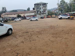 eine Gruppe von Autos, die auf einem unbefestigten Parkplatz geparkt sind in der Unterkunft JAIN HOTEL,Pachmarhi in Pachmarhi