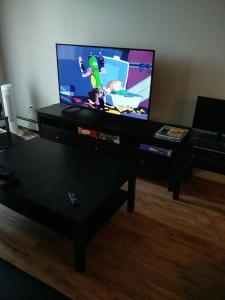 a living room with a tv with a video game on it at Mike's Studio off Whyte! in Edmonton