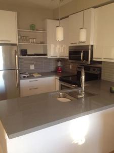 a kitchen with a sink and a stainless steel refrigerator at Mike's Studio off Whyte! in Edmonton