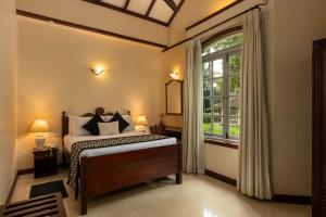 Rúm í herbergi á Tamarind Tree Garden Resort - Katunayake