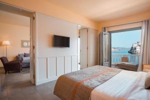 ein Schlafzimmer mit Bett und Blick aufs Wasser in der Unterkunft Megisti Hotel in Megisti