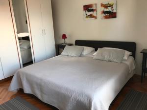 una camera da letto con un grande letto bianco con due cuscini di Apartment in Lovran with terrace, air conditioning, WiFi, washing machine 3735-1 a Lovran (Laurana)