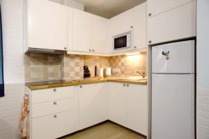 una cucina con armadietti bianchi e frigorifero di La Garita beach a La Garita