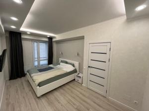 a small bedroom with a bed and a window at Dendrarium Park Apartment in Chişinău