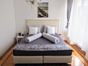 1 cama con almohadas en el dormitorio en City Villa Schönbrunn Apartments - Contactless 24h Check-In, en Viena