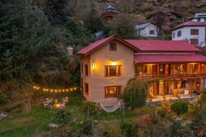a house with a red roof with lights in the yard at Zostel Homes Laida, Jibhi in Sainj +73 photos
