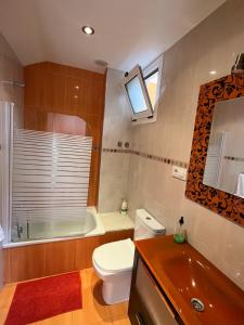 La salle de bains est pourvue de toilettes, d'une baignoire et d'un lavabo. dans l'établissement ApartamentosArturo Llanes LaPlaza Atico céntrico, à Llanes