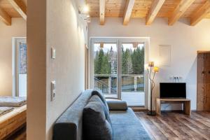 a living room with a couch and a large window at Ferienwohnung Daniel in Ehrwald