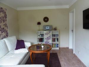 a living room with a white couch and a table at Antoinettes Ferienwohnung in Ilmenau