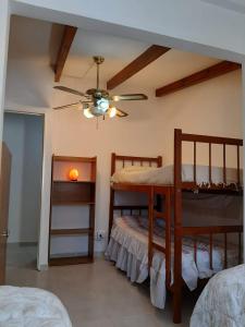 a bedroom with two bunk beds and a ceiling fan at Cabañas Cerros Azules en La Rioja Alojamiento Temporario in La Rioja