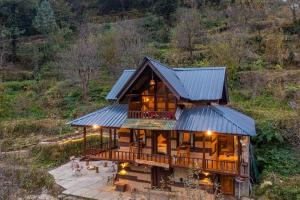 a log home with a metal roof and a deck at Zostel Homes Laida (Jibhi) in Sainj