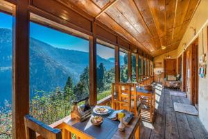 a room with a table and chairs and windows at Zostel Homes Laida, Jibhi in Sainj