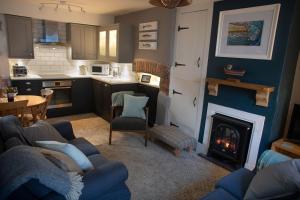 a kitchen with a living room with a fireplace at Brakestone Cottage in the heart of Port Isaac in Port Isaac