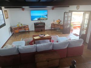 a living room with a couch and a tv at Habitaciones Doña Cris in Puerto del Carmen