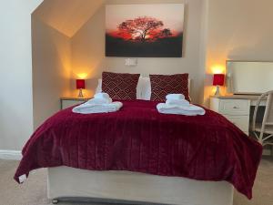a bedroom with a purple bed with towels on it at The Sandrock in Clacton-on-Sea