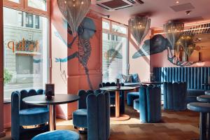 a restaurant with two tables and blue chairs at VISIONAPARTMENTS Brandschenkestrasse in Zurich