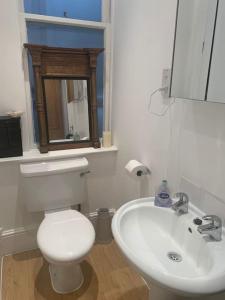 a bathroom with a white toilet and a sink at Central London (West End) two bedroom flat in London