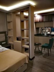 a bedroom with a bed and a kitchen and a table at Luxury Hotel Suite Apartment in Batumi