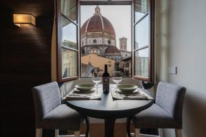 a table with two chairs and a bottle of wine at Giotto Suite With View in Florence