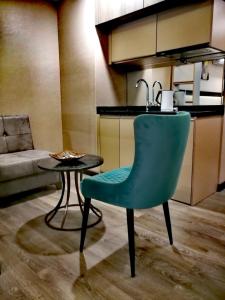 a green chair sitting next to a table in a kitchen at Luxury Hotel Suite Apartment in Batumi
