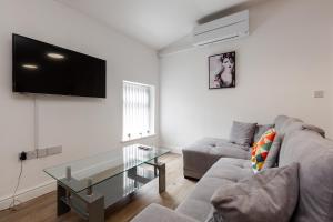 a living room with a couch and a glass table at York Villas Free Parking Included in Liverpool