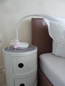 a nightstand next to a bed with a lamp on it at Antoinettes Ferienwohnung in Ilmenau