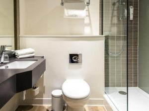 a bathroom with a toilet and a sink and a shower at Holiday Inn Swindon by IHG in Swindon