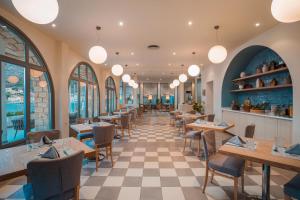 ein Restaurant mit Tischen, Stühlen und Fenstern in der Unterkunft Megisti Hotel in Megisti