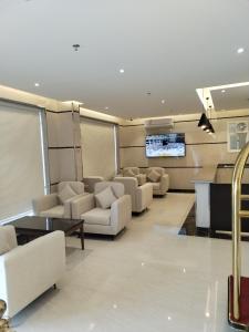 a living room with couches and a flat screen tv at الشرق بارك للشقق المخدومة in Al Mikhlaf