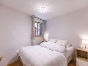 a bedroom with a white bed with a window at T2 cosy en centre-ville avec parking, proche commodités, 3 stations de ski, non fumeur - FR-1-402-118 in Luz-Saint-Sauveur